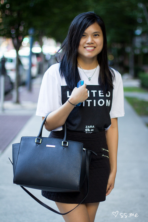 photo of woman in tshirt holding black handbag - fashion affliate network
