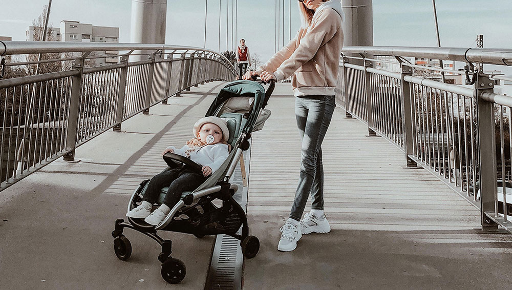Woman pushing a toddler in a stroller for Quinny influencer campaign